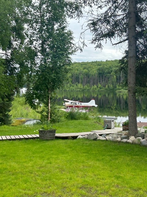 Floatplane beside a forested lake in Alaska