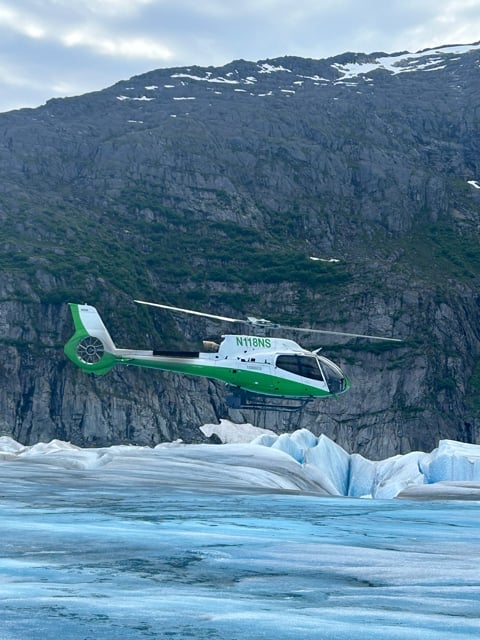 Green helicopter landed on an Alaska glacier
