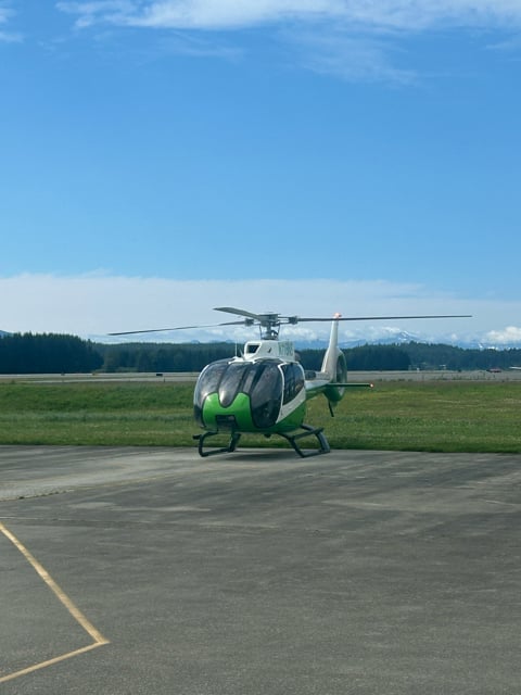 Green helicopter parked on an Alaska airfield