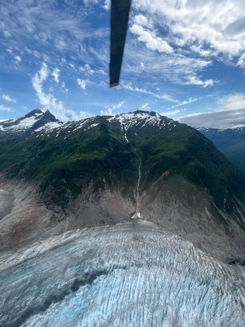Helicopter rotor above an Alaska glacier valley