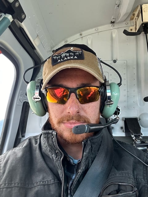 Passenger wearing a headset inside an Alaska helicopter