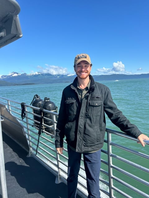 Portrait on an Alaska boat deck with mountains behind