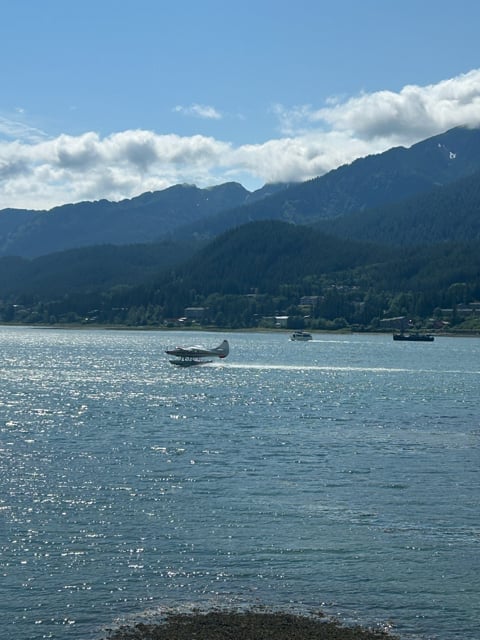 Small boat crossing an Alaska bay below mountains
