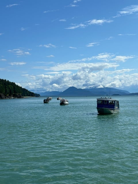 Small boats on turquoise water with Alaska mountains