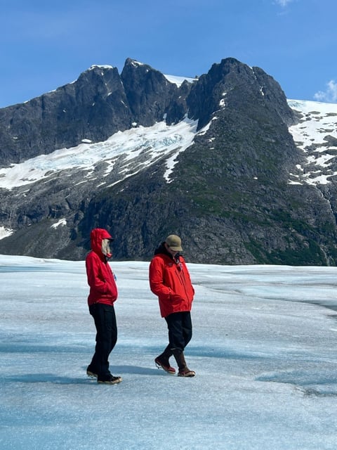 Two people walking across an Alaska glacier